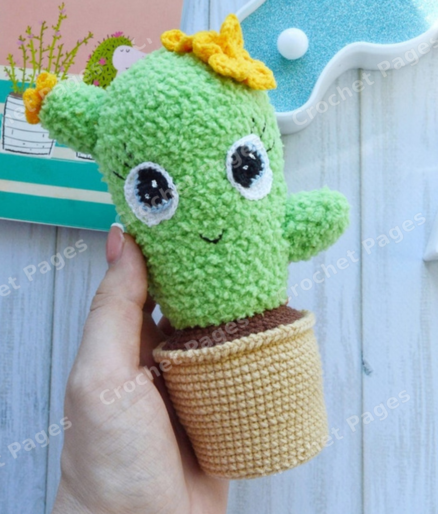 Make a soft cactus with two side shoots, large layered eyes, crocheted flowers and an integrated pot and soil section. Finished-project view.