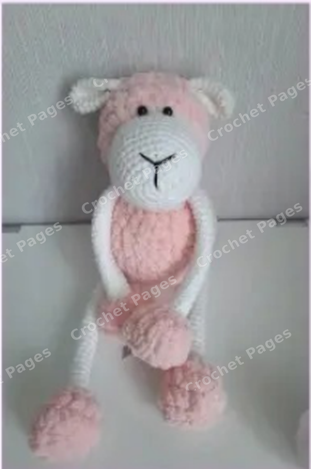 Make a soft sheep with a fluffy body, long slender limbs and folded ears, suitable for seated display. Detail of the crocheted project.
