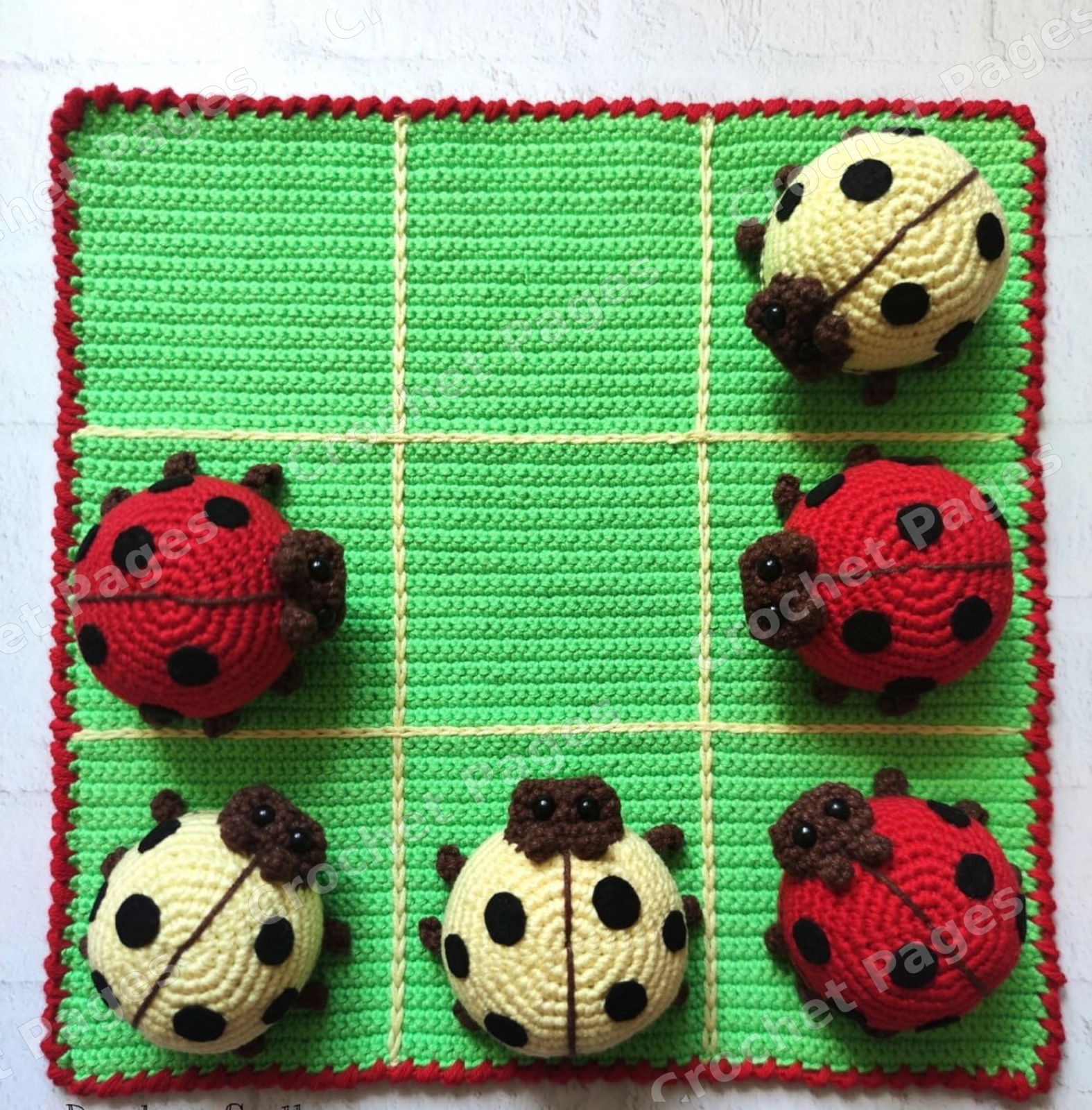 Crochet a square tic-tac-toe board and ten rounded ladybug playing pieces in two colors. Includes board edging, surface grid lines, shaped faces and felt spots. Finished-project view.