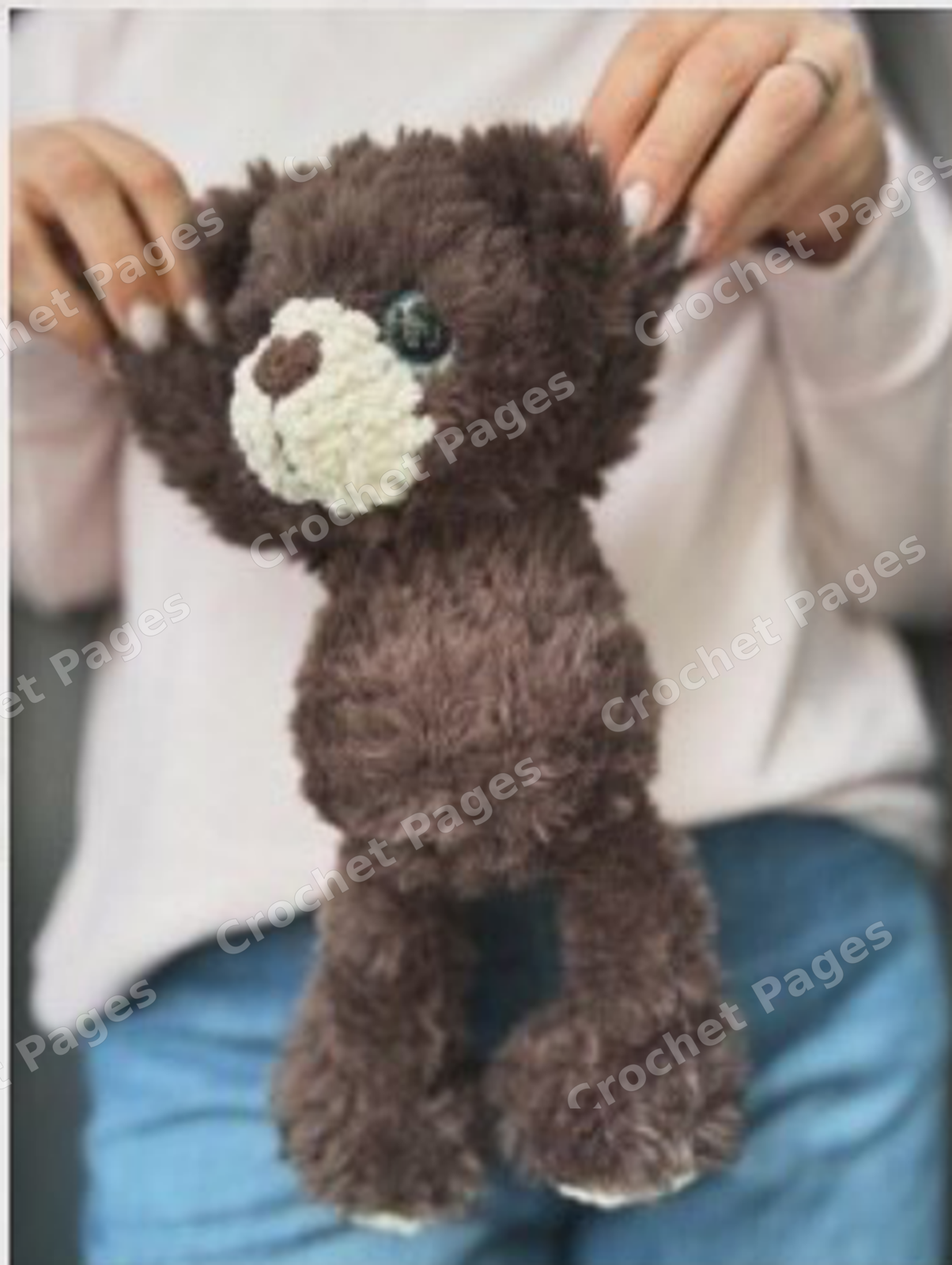 Make a fuzzy teddy bear with contrasting paws and muzzle, large eyes and a sculpted face. Limbs and tail are joined while crocheting the body. Detail of the crocheted project.