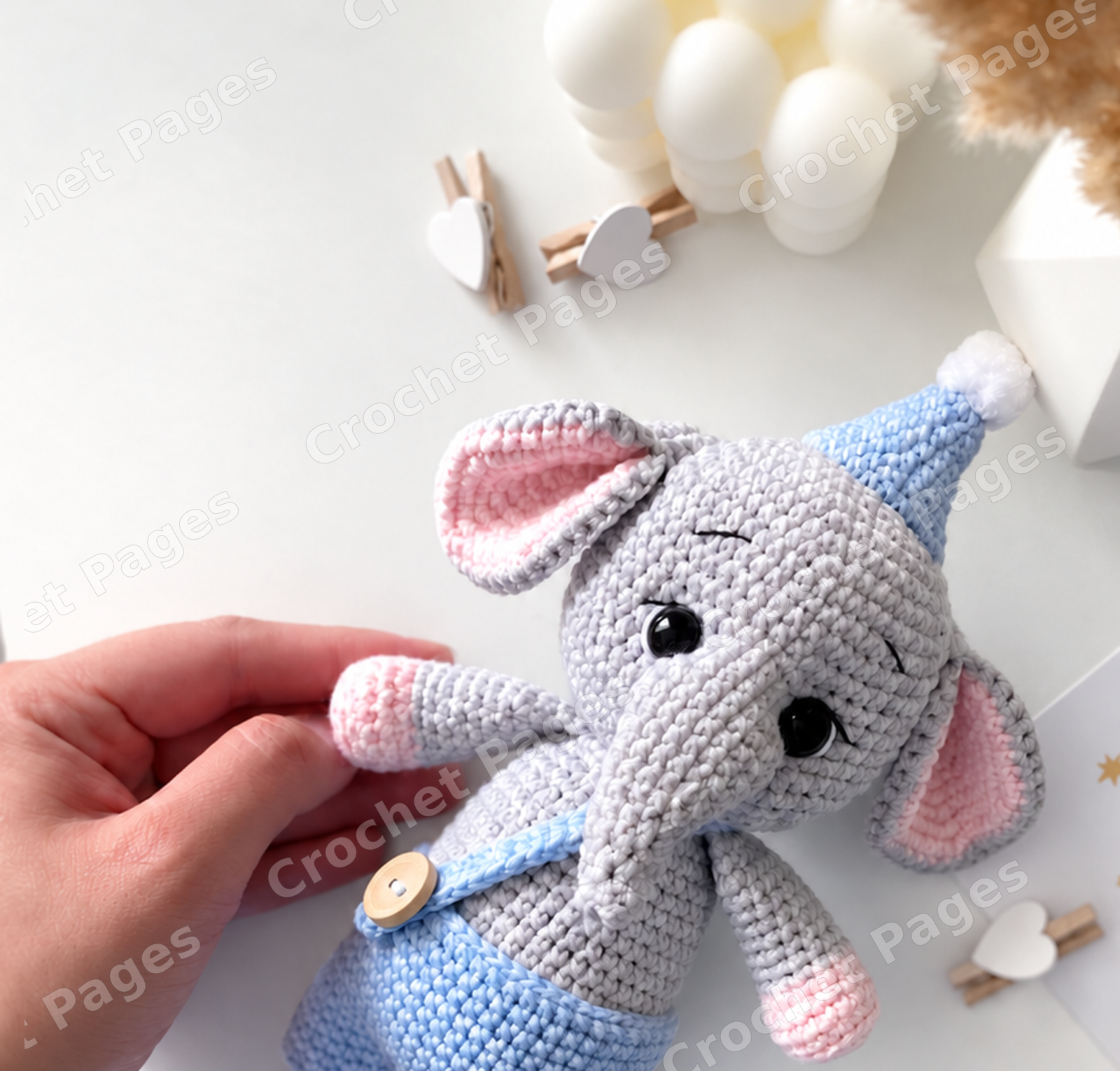 Crochet an elephant with a curved trunk, wide ears and contrasting paws, plus a crocheted cap and removable overalls. Detail of the crocheted project.